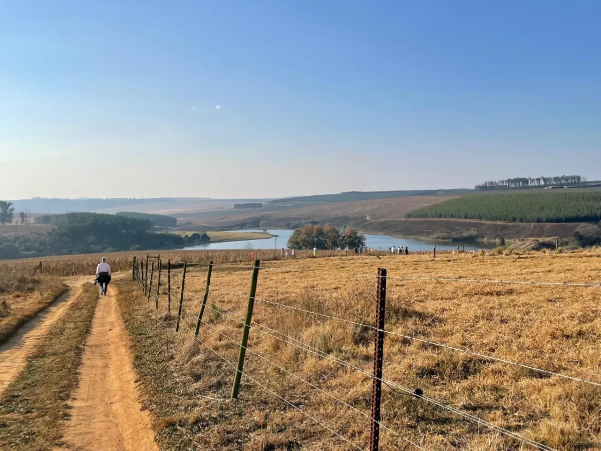 People walking beside a farm dam on a rural route near Hermannsburg
