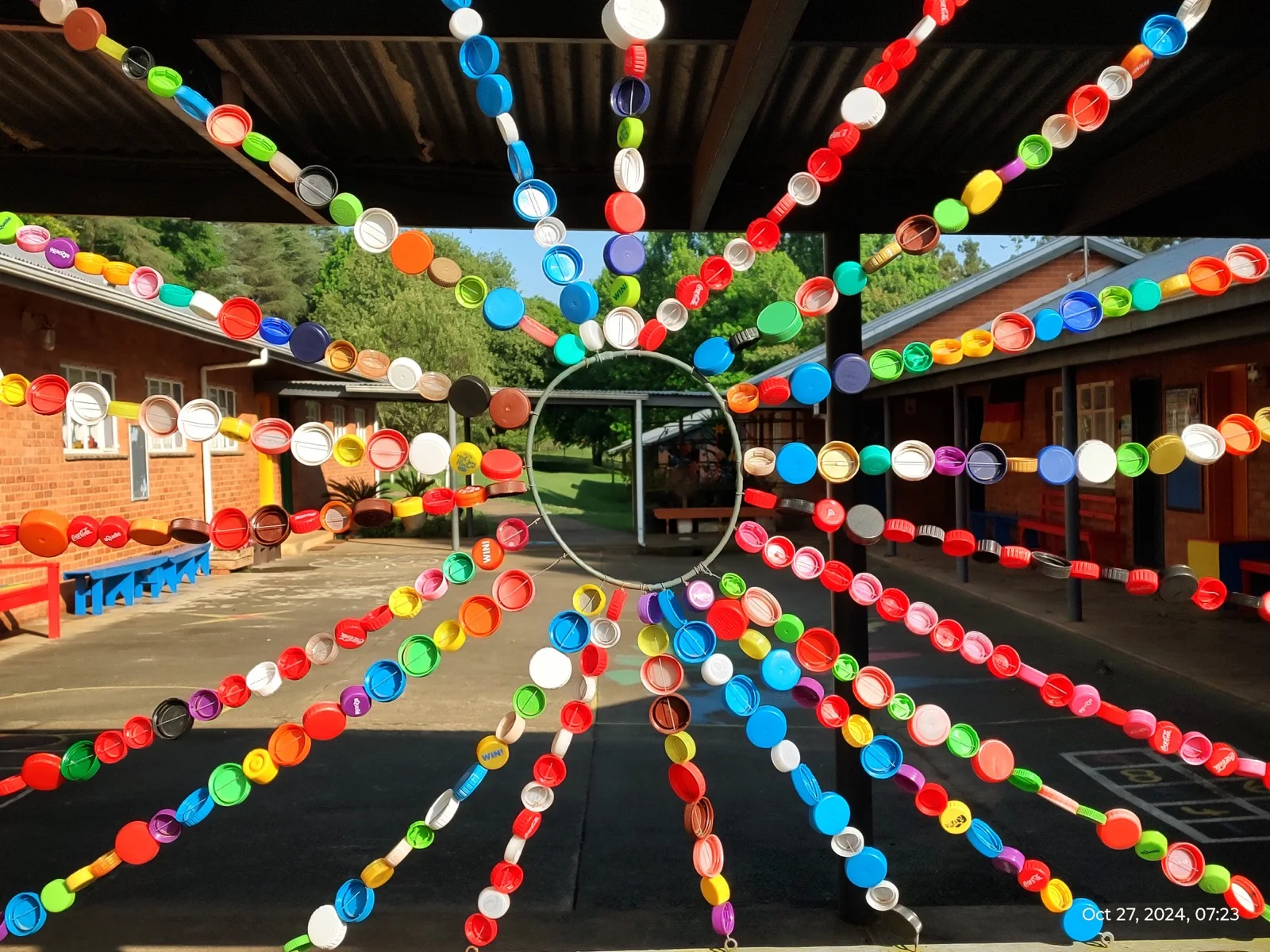 Colourful recycled-cap artwork in a school courtyard